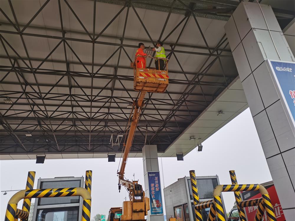 邢台养护工区协助鸡泽收费站维修顶棚灯。