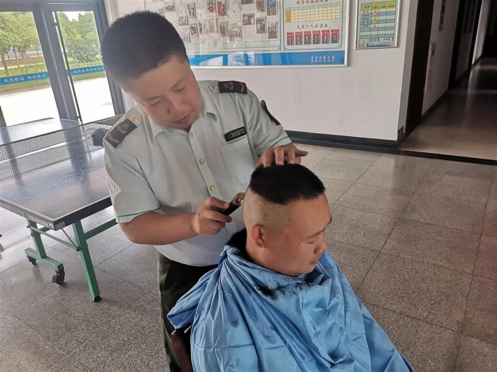 在鸡泽收费站的办公楼大厅里,收费人员手持理发工具,正在为他的第一位“顾客”修剪头发。